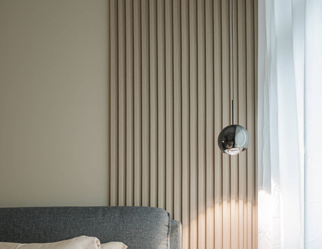 Fluted panel decorates a small portion of the wall, creating a sleek and modern look in the bedroom